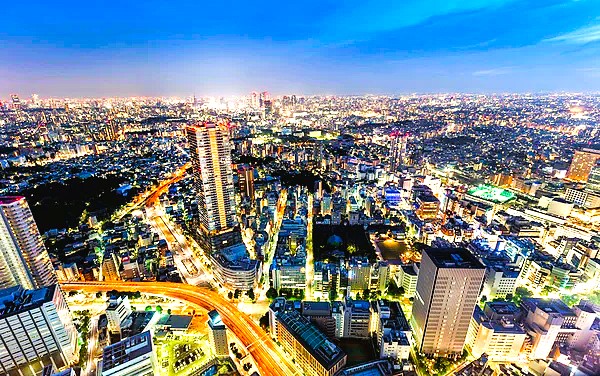 Shibuya crossing in Tokyo illuminated at night with crowds